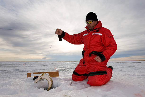 Fishing on ice Ice fisherman catching a fish on a hand line man ice fishing stock pictures, royalty-free photos & images