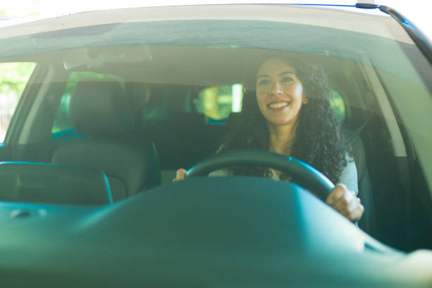 istock Happy young woman driving her car 1451627708