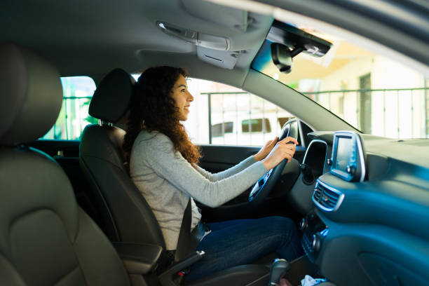 istock Attractive woman smiling while driving 1451627740