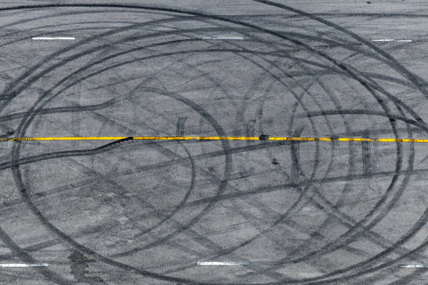 istock Top view tire tracks texture and background, Asphalt texture with line and tire marks, Automobile automotive tire skid mark on race track, Abstract texture car drift tire skid mark. 1451630133