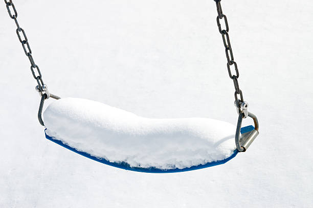 Playground swing in snow stock photo