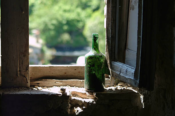 Vecchio verde bottiglia di vino in finestra - foto stock