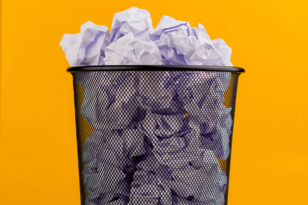Asian preschooler exciting while learning how to sort plastic and paper trash with mom at home.