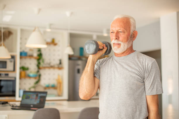 istock Senior man at home keeping fit by exercising 1451638912