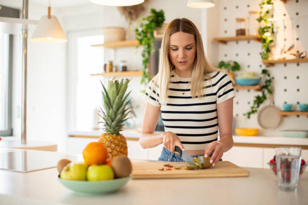 istock Beautiful young woman having breakfast in the kitchen 1451639098