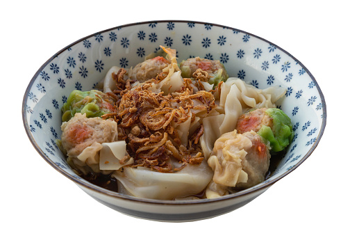 Wide rice noodles and Dumpling sprinkled with Fried shallots with Dried shredded pork in bowl isolated on white background with clipping path. Selective focus.