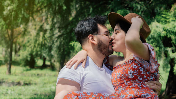 istock Handsome man holding his girlfriend in his hands in a park. 1451641919