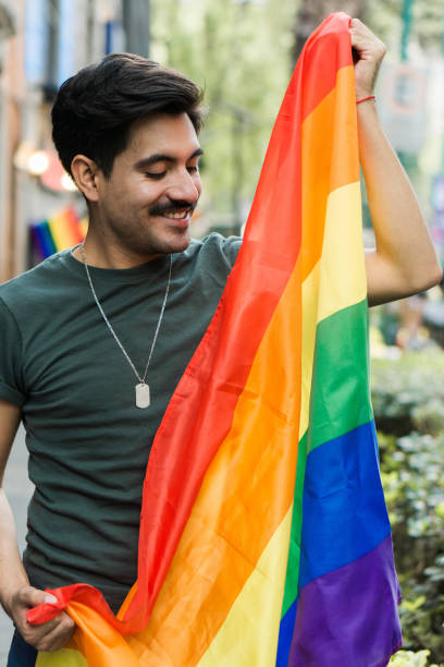 istock Hispanic man with beard and LGBT flag, smiling. 1451643631