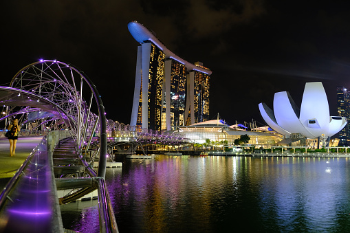The Helix Bridge, a pedestrian bridge linking Marina Centre with Marina South in the Marina Bay area in Singapore. In the distance, the Artscience Museum and the Marina Bay Sands.