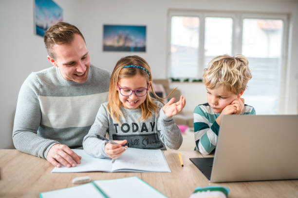istock Caucasian Single Dad Helping Son and Daughter with Homework 1451644062