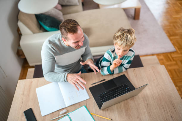istock High Angle View of Two Family Members Working on Laptop 1451644095