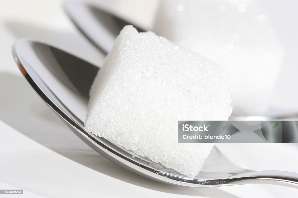 sugar cubes on spoons sugar cubes on silver spoons Cube Shape Stock Photo