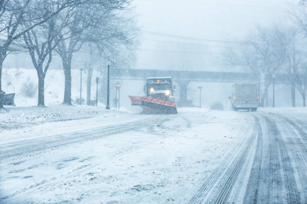 Winter Snowplow Dump Truck Approaching During Snow Storm stock photo