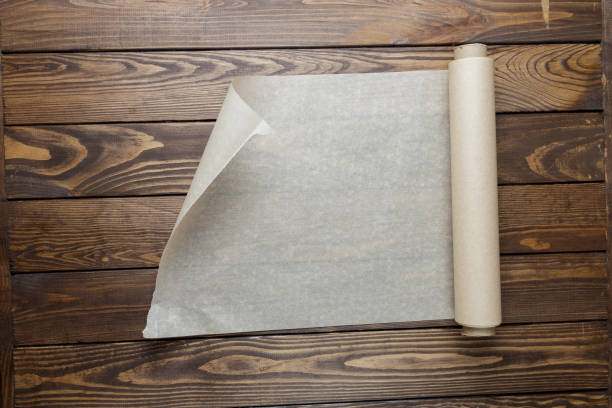 istock baking paper on a wooden background. unrolls a roll of baking paper. 1451650798
