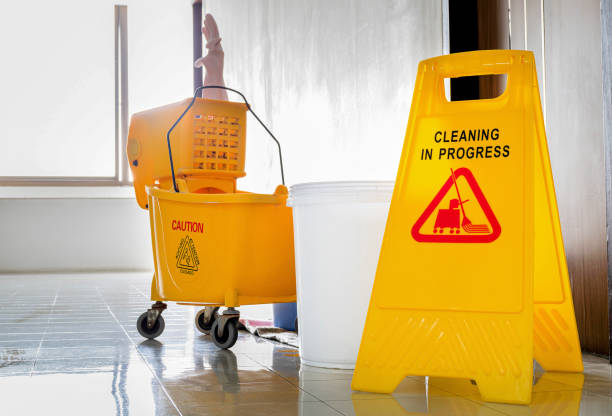 istock Close up yellow warning sign with message Cleaning in progress with cleaning trolley background 1451658982