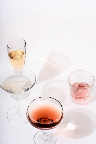 istock Pattern of glasses for wine and various drinks with daylight and dark shadows on a pink background. The concept of wine tasting, assorted glasses with different drinks. 1451659320