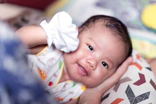 Young baby playing with mother and sleeping after breastfeeding - Stock photo