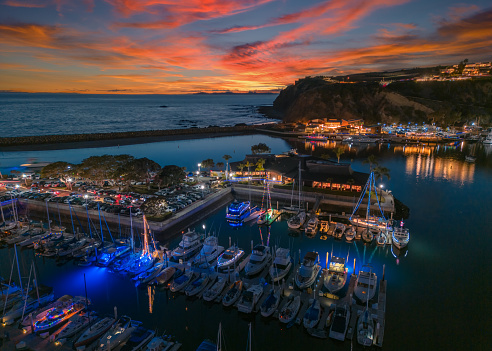 Dana Point Harbor at sunset with a cloudscape in the background.