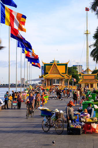 Phnom Penh, Cambodia - November 30, 2022: People walking in the evening along the Mekong River waterfront esplanade in Phnom Penh, Cambodia.