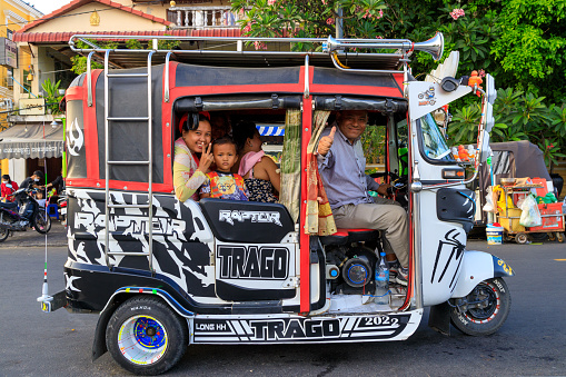 Phnom Penh, Cambodia - November 30, 2022: Street scene of a tuk tuk in Phnom Penh, Cambodia a common form of transportation in the city.