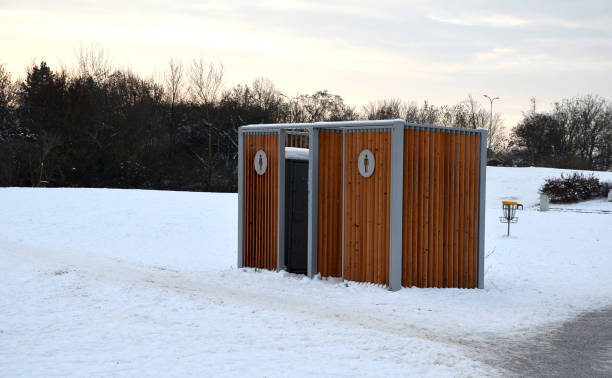 istock closing cage for placing chemical toilets. unsightly plastic boxes are inside a metal house with a flat roof and wooden slats on the walls. athletes in park or mothers with children can pee, wash hand 1451677032