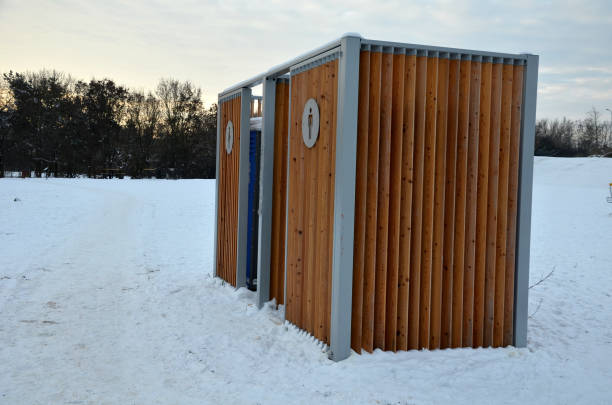 istock closing cage for placing chemical toilets. unsightly plastic boxes are inside a metal house with a flat roof and wooden slats on the walls. athletes in park or mothers with children can pee, wash hand 1451678696