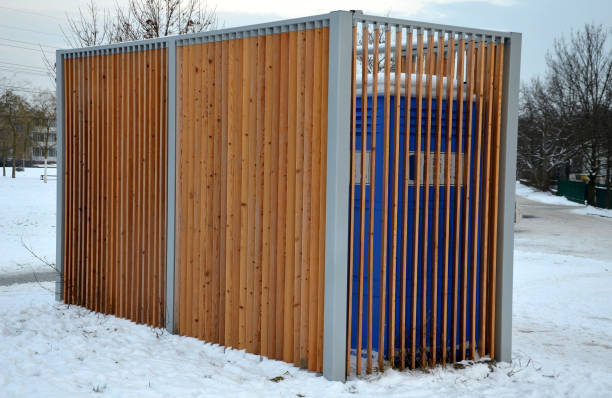 istock closing cage for placing chemical toilets. unsightly plastic boxes are inside a metal house with a flat roof and wooden slats on the walls. athletes in park or mothers with children can pee, wash hand 1451679145
