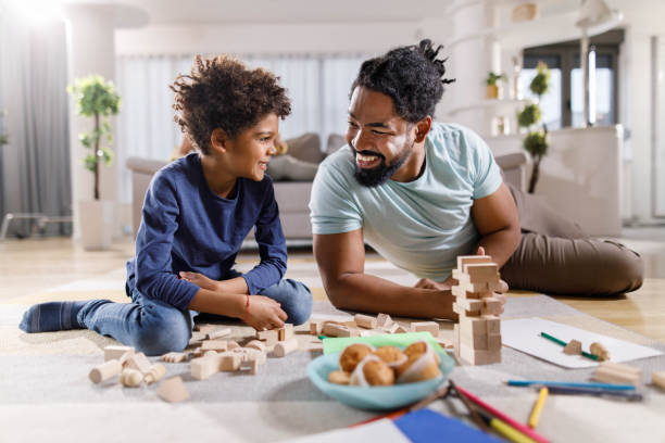 istock Black single father and son playing with toy blocks at home. 1451679531