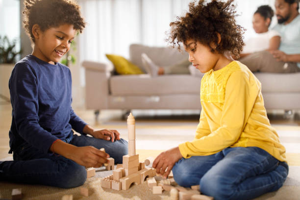 istock Small black siblings playing with toy blocks at home. 1451680814