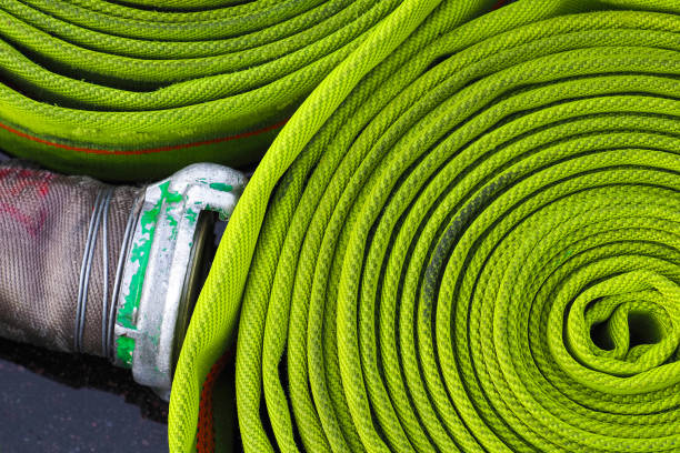 Rolled into a roll, green fire hose with aluminum connective coupling. Equipment for fire fighting