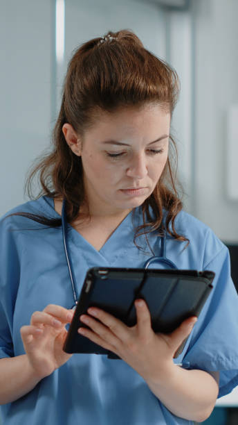 istock Close up of medical assistant looking at tablet screen with information 1451692145