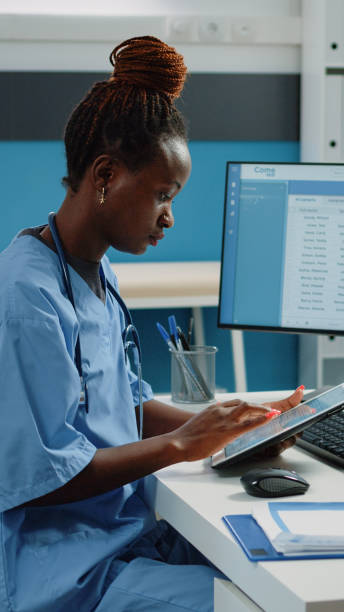istock African american nurse using digital tablet for treatment 1451693624