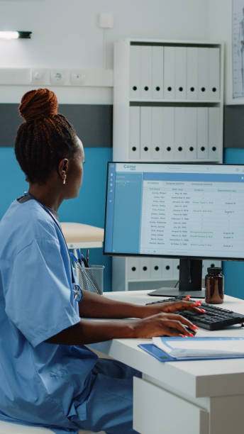 istock Medical assistant typing on computer keyboard in cabinet 1451694568