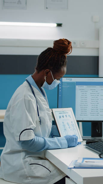 istock Doctor showing bones anatomy on tablet while wearing face mask 1451694620