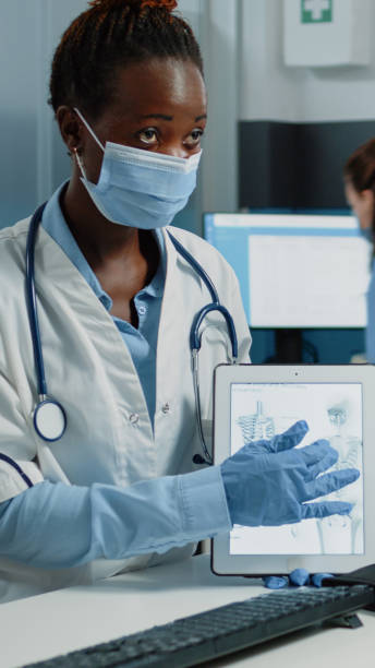 istock Medic explaining bones fracture to patient for osteopathy examination 1451695269