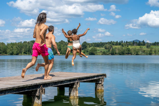 istock Friends jumping into lake 1451695769