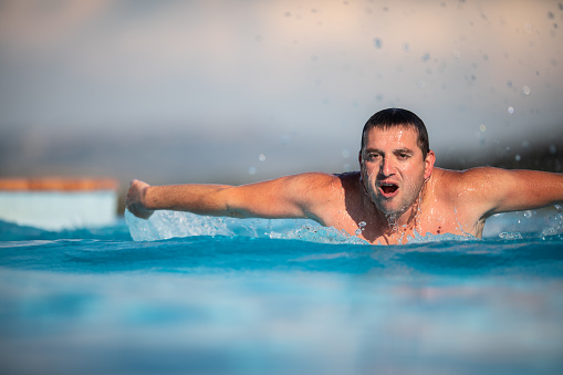 Male swimmer swimming in an outdoor pool - keeping fit