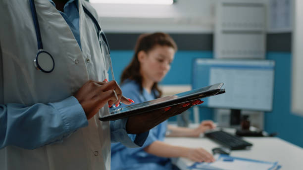 istock Close up of african american doctor using tablet with touch screen 1451696523