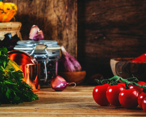 istock Cooking food background with tomatoes, pumpkins, herbs on rustic wooden kitchen table with cast iron pan, spice grinders, cutting board, spices and seasonings, storage jars 1451699460