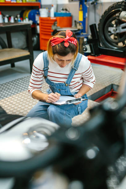 istock Mechanic reviewing documentation of motorcycle on garage 1451707251