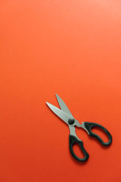 istock Big black scissors on red background vertical. place for text 1451707449