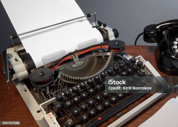 Retro Old Typewriter From 70s With Paper Blank On Wooden Table Vintage Place For Text Stock Photo - Download Image Now