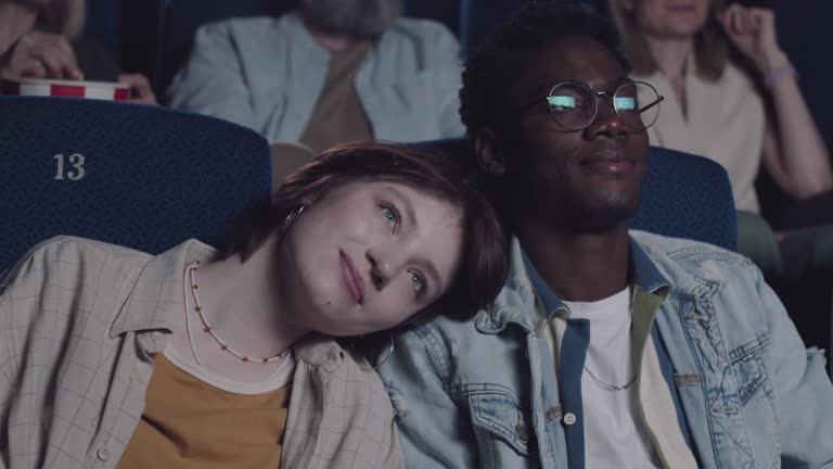 Ethnically Diverse Couple Enjoying Movie In Cinema