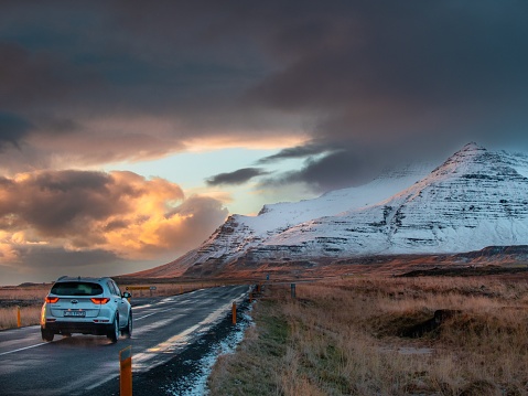 Vik, Iceland – November 23, 2021: A country road to ice-covered mountains at sunset