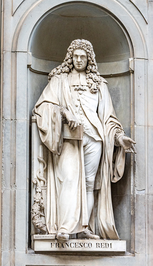 A sculpture of Francesco Redi (1626-1697) an Italian physician, naturalist, biologist, and poet by Pietro Costa made in the 19th century in the open public space of the Niches of the Uffizi Colonnade in Florence, Italy. Redi was known as the father of experimental biology and parasitology because he challenged the theory of spontaneous generation by showing that maggots wwre born of fly eggs.