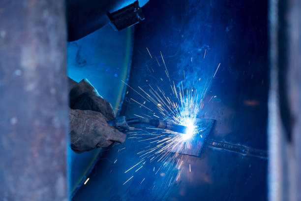 istock Skillful metal worker working with arc welding machine in factory while wearing safety equipment. Metalwork manufacturing and construction maintenance service by manual skill labor concept. 1451725539