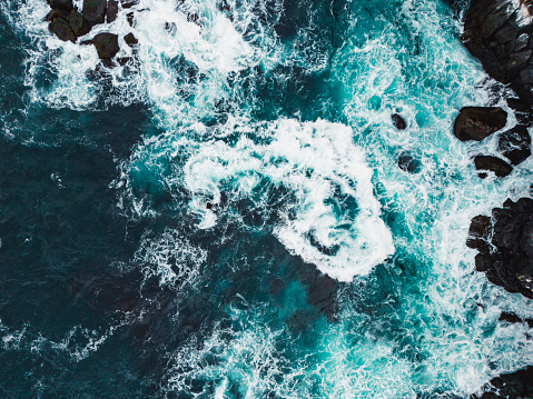 Top down view of waes crushing in the sea in West Iceland highlands, Snaefellsnes peninsula, View Point near Svortuloft Lighthouse. Spectacular black volcanic rocky ocean coast with cave arch and towers. High quality photo