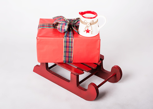 Sledge, gift and Christmas mug on white background