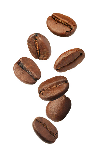Muchos granos de café tostados volando sobre fondo blanco photo