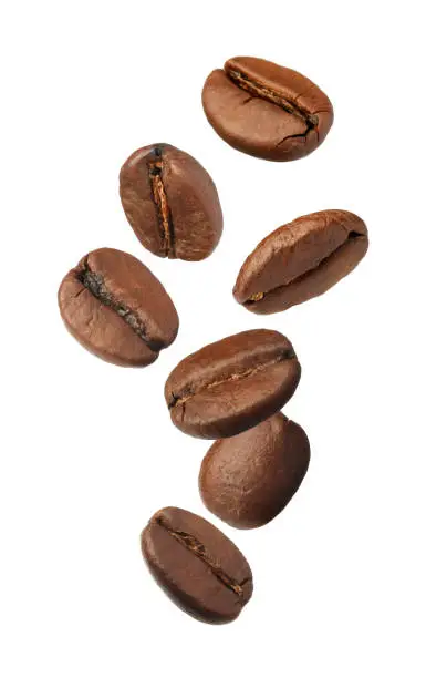 Photo of Many roasted coffee beans flying on white background